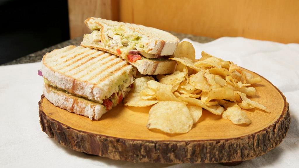 Flying Scotsman Sandwich · Grilled sourdough smothered in aged provolone, layered with plump grilled chicken breast, sauteed red pepper, onion and topped with pesto mayo. Hot grilled panini served with home-style kettle chips.