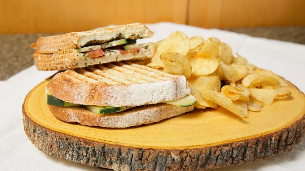 Trans-Siberian Sandwich · Grilled sourdough smothered in melted brie, layered with ripe roma tomato, fresh basil, crispy cucumber and seasoned olive oil. Hot grilled panini served with home-style kettle chips.
