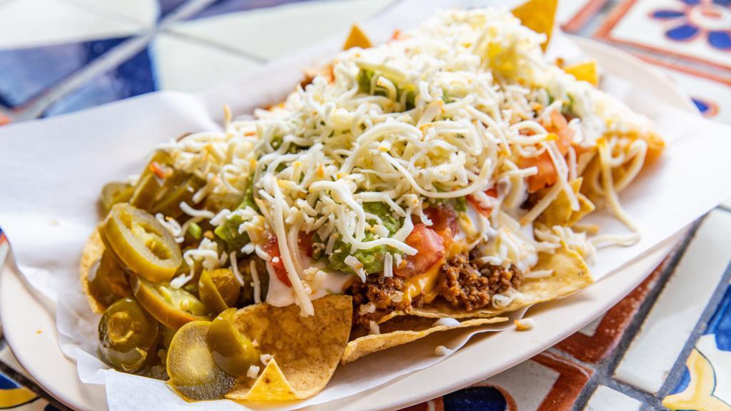 Nacho Supreme · Choice of meat expect lengua or steak. Beans, tomatoes, shredded cheese, nacho cheese, jalapeños, sour cream, guacamole.