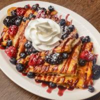 Triple Berry French Toast · Topped with fresh blackberries, raspberries, blueberries, powdered sugar, and Melba sauce.