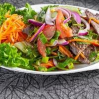 Mint Beef Salad · Grilled beef tossed with herbs, tomatoes, and cucumber served over mixed greens.