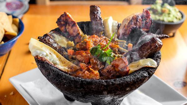 Molcajete Surtido · (Lava Stone)Skirt Steak, Chicken, chorizo, Panela cheese, grilled cactus, onions, salsa rustica. Served with handmade tortillas to make your own tacos.
