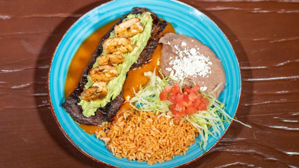 Mar Y Tierra · Charbroiled skirt steak served over our ranchero sauce and topped with grilled shrimp, served with guacamole, rice and beans