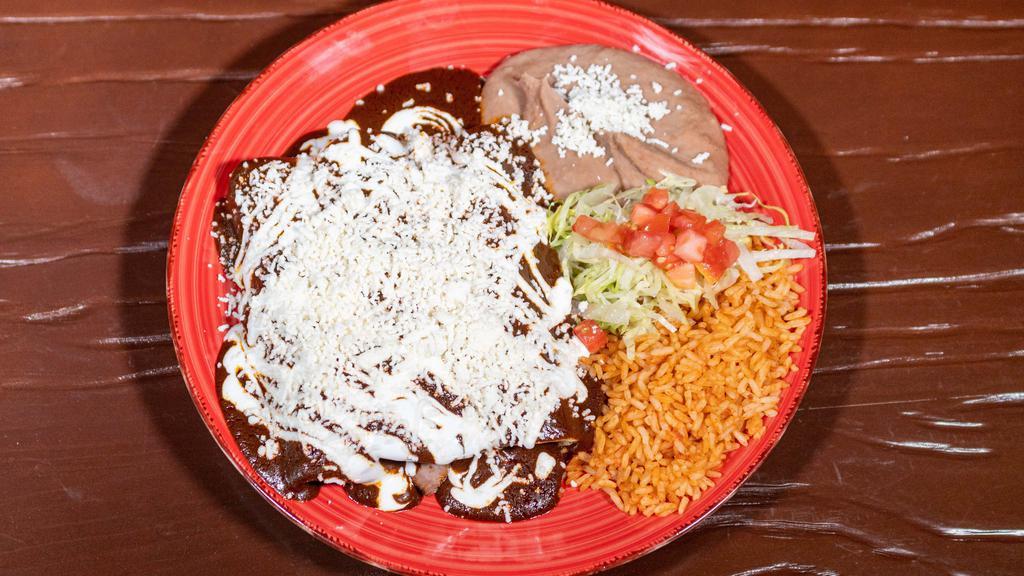 Enchiladas De Mole · 3 enchiladas topped with our signature mole sauce, melted cheese, sour cream and filled with your choice of meat (steak, al pastor, chicken, ground beef or veggies).