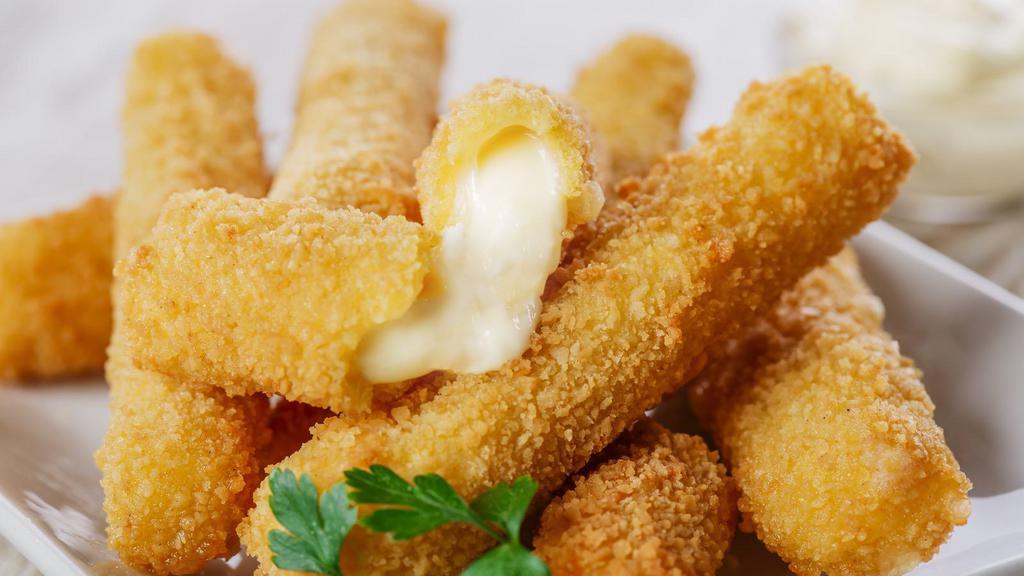 Mozzarella Sticks · Creamy mozzarella cheese sticks breaded with crushed corn tortilla chips, served with a side of warm queso.