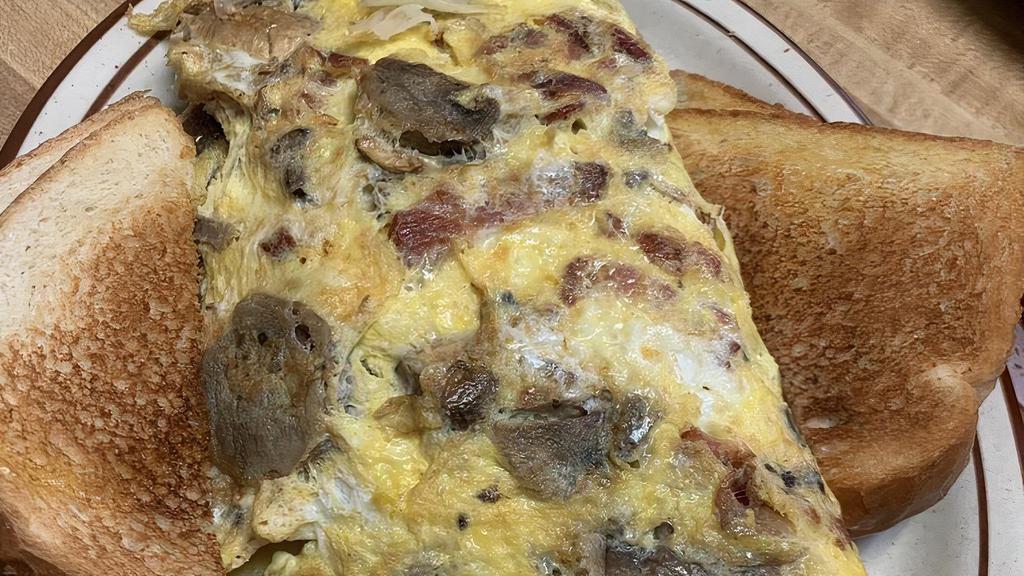 House Omelette · Hash browns, ham, mushrooms, green peppers, onions, topped with cheddar cheese, two eggs any style with pancakes or toast