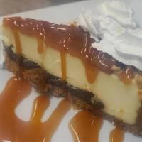 Turtle Cheesecake · Our New York style cheesecake on a layer of fudge, topped with caramel sauce and garnished w...