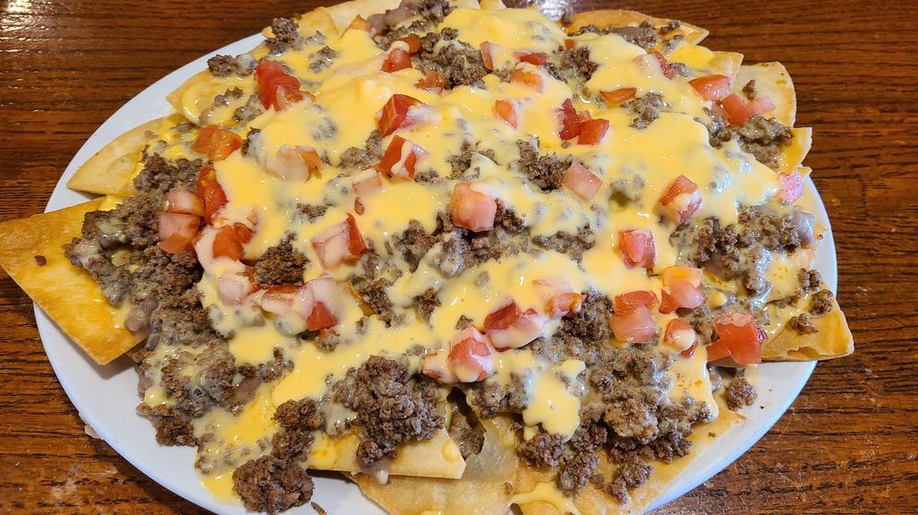 Nachos Supreme · Corn or fresh fried flour tortilla chips topped with seasoned beef, beans, cheese, and tomatoes.