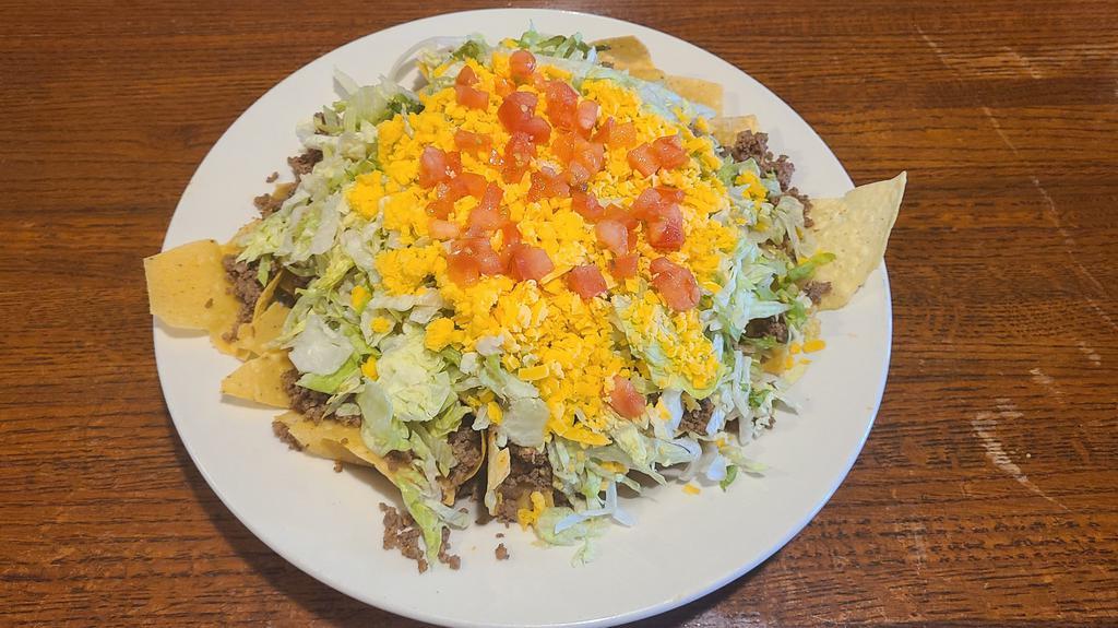Taco Salad Chip Style · Crisp lettuce, your choice of seasoned beef or chicken, tomatoes and cheese on a bed of tortilla chips.
