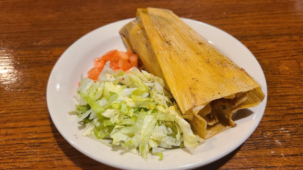 Tamales · Shredded pork and masa cooked in corn husk, served with lettuce & tomatoes on the side.