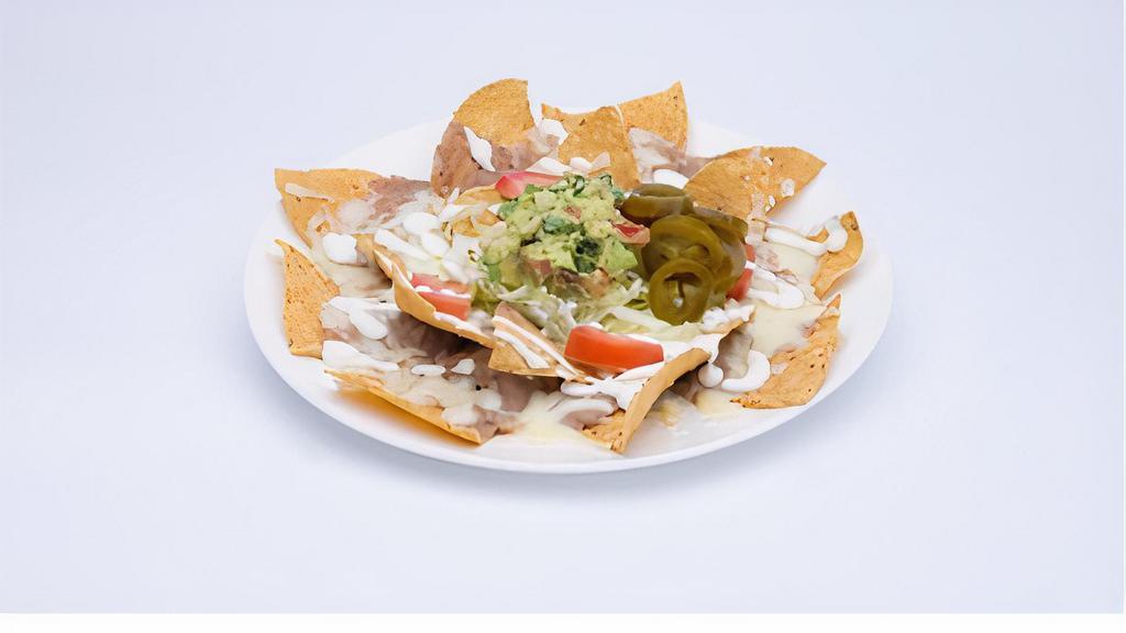 Nachos · Chips, beans, cheese dip, tomato, cilantro, jalapeño peppers, sour cream and guacamole. Add meat for an additional cost.
