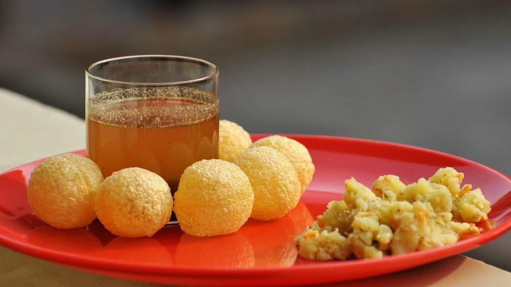 Pani Puri · Consists of round, hollow puris, fried crisp and filled with a mixture of flavored water (commonly known as imli pani), tamarind chutney, chili, chaat masala, potato, onion or chickpeas.