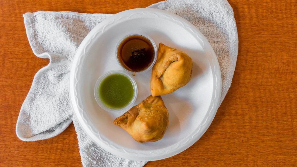 Samosa · A very popular Indian snack. Triangular shaped, fried dish with a savory filling of spiced potatoes, onions and peas. Served with mint and sweet chutneys.
