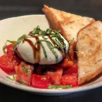 Burrata Caprese · Burrata mozzarella, smoked cherry tomato, balsamic glace, pesto, basil, and garlic.