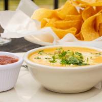 Queso With Tortilla Chips · Mexican Cheese with Spicy Sausage. Topped with cotija cheese, cilantro, and guacamole. Serve...