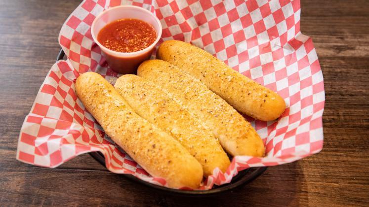 Soft Bread Sticks · Four soft bread sticks seasoned with our special garlic seasoning, topped with Romano cheese, served with a side of Marinara.