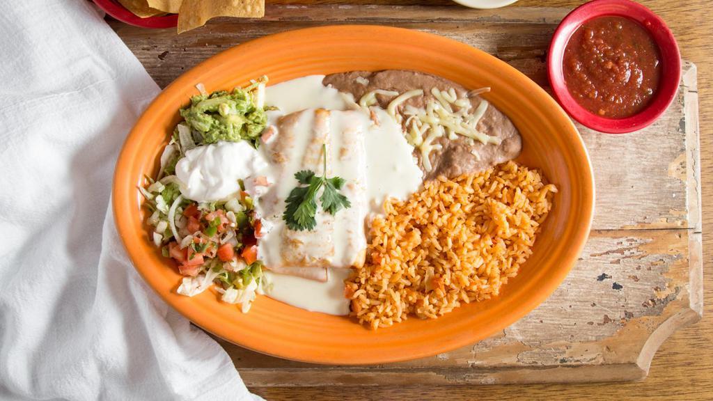 Chimichanga · Beef tips or chicken and beans wrapped in a flour tortilla, deep-fried topped with cheese dip. Served
with rice, beans, sour cream and guacamole salad.