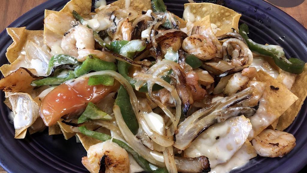 Grilled Shrimp Nachos (Half) · A bed of crispy tortilla chips smother with our exquisite cheese dip topped with succulent grilled shrimp. add fajita veggies for a bit more