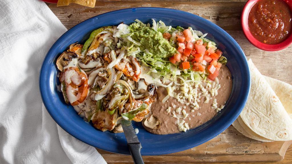 Pollo A La Parrilla · We’ve smothered an already perfect chicken breast with seared mushrooms, bell peppers, onions, and cheese dip. Served with guacamole salad, beans, and tortillas.