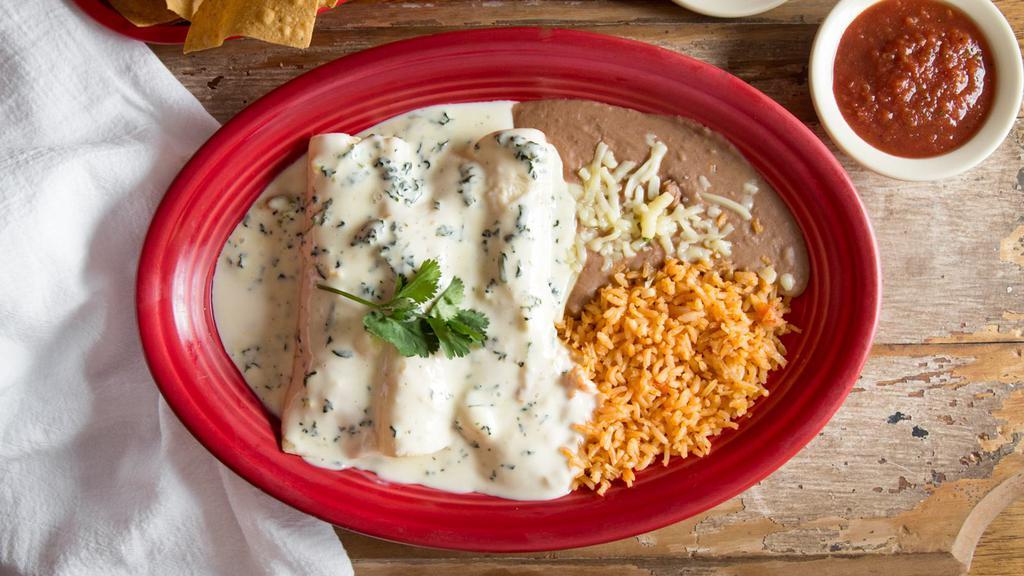 Popeye Enchiladas · Three chicken and spinach enchiladas topped with our savory Spinach dip served with rice and beans.
