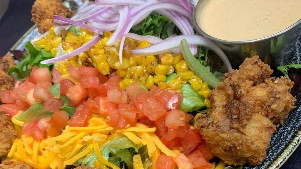 Southwest Ranch Salad · Southern fried buttermilk thighs with tomatoes, red onion, roasted sweet corn, cheddar cheese and mixed greens, served with haus made southwest ranch dressing. (dressing on side)