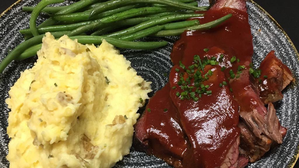 Smoked Beef Brisket · Tender beef brisket smoked in haus' over apple and hickory then glazed with our haus bbq sauce, sour cream and chive mashed, and French beans.