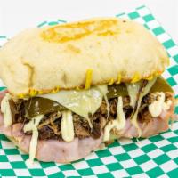 Cubano · Succulent pork slowly braised in herbs and spices, ham, Swiss cheese, pickles, mustard and m...