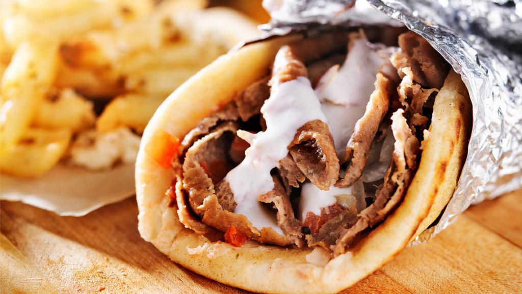 Beef Shawarma Pita · Mouthwatering Beef Shawarma made artfully in a pita with lettuce, tomatoes, onions, cucumbers and tahini sauce.