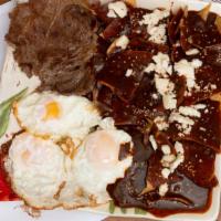 Chilaquiles Steak In Red Mole  · Grilled Steak , tortilla slices in Red Mole,  sesame seeds topped with two eggs, rice, beans...