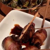 Bacon Wrapped Dates · Stuffed with thyme and romano and drizzled with balsamic reduction.