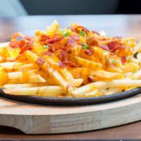 Bacon Cheese Fries · Fresh batch of french fries with melted cheese on top and bits of bacon.