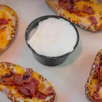 Potato Skins · Deep-fried potato skins topped with cheddar jack cheese, sour cream, and bacon.