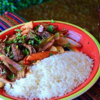 Lomo Saltado · Marinated steak strips stir-fried with onions, and tomatoes in soy sauce and aji amarillo. S...