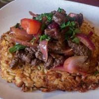 Tacu Lomo · Rice cooked with Canario Beans, garlic, and aji amarillo.  Served with Lomo stir fried Steak...