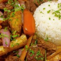 Lomo Saltado · Strips of beef tenderloin sauteed with red onions, tomatoes and soy sauce, combined with fre...