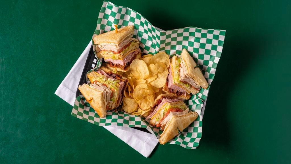 The Club · Lettuce, tomato, mayo, turkey, ham, bacon, American and swiss cheese on toast with chips.