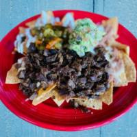Nachos Don Pepe · Tortilla chips smothered in melted cheese, guacamole, sour cream & beans with jalapeños with...