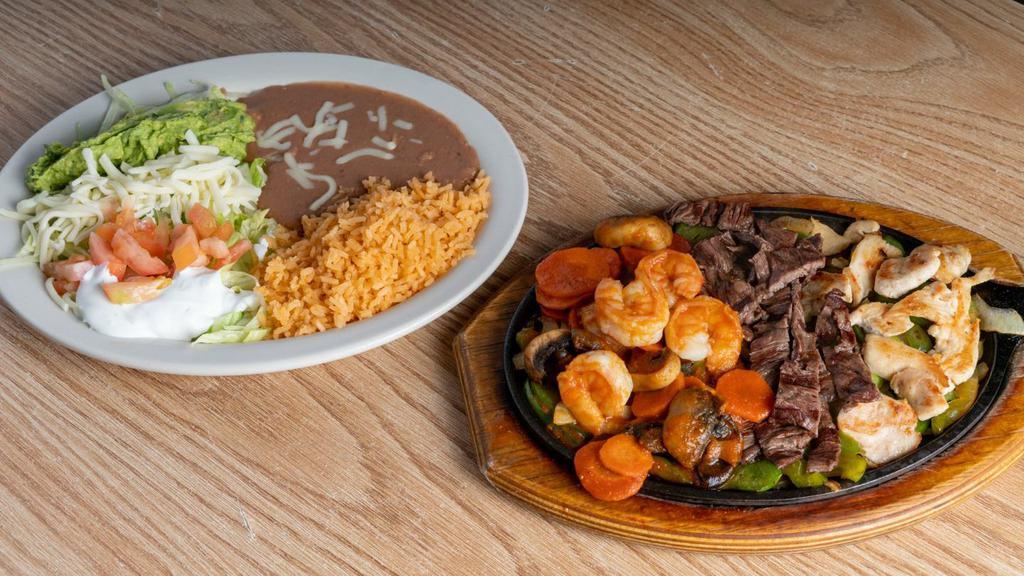 Trio Fajitas · Fajitas with steak, shrimp, and chicken, cooked with carrots, mushrooms, bell peppers, and onions.