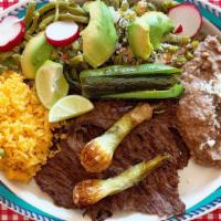 Carne Asada · Charbroiled steak, topped with nopales (cactus), cebollitas(scallions) and chiles toreados (...