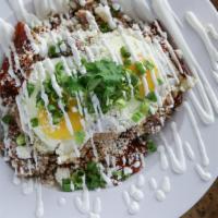 Chilaquiles Rojos · White corn tortillas tossed in ancho-guajillo sauce topped with carnitas, 2 eggs, queso fres...