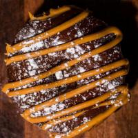 Buckeye · Chocolate dip with peanut butter drizzle and powdered sugar.