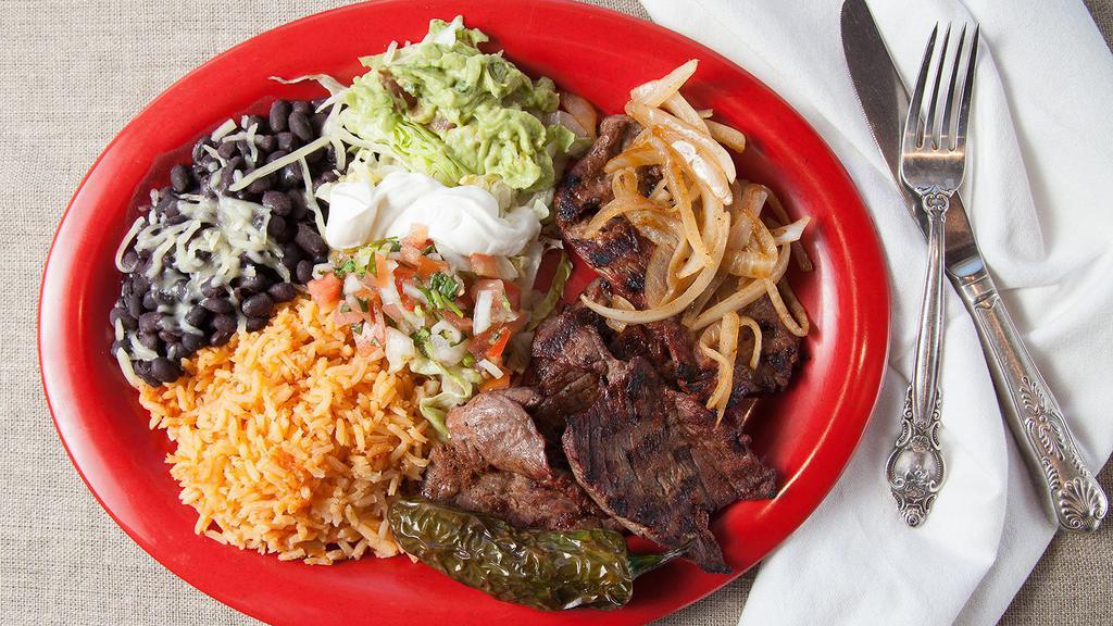 Carne Asada Plate · Carne asada served with rice, beans, sour cream, guacamole, lettuce and two tortillas of your choice on the side.