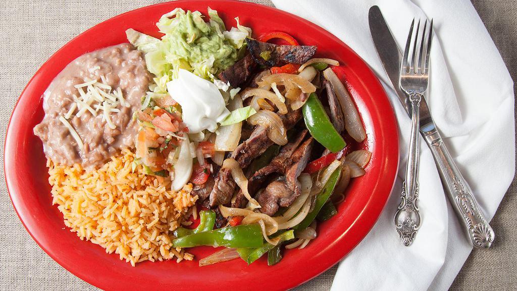 Steak Fajitas · Served with grilled bell peppers, onions and jalapenos, with rice, beans, sour cream, guacamole, lettuce and two tortillas of your choice on the side.