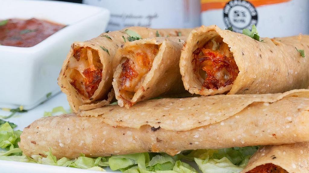 Chicken Tinga Taquitos (Gf) · Perez corn tortillas stuffed with our signature cheese blend and spicy marinated chicken then flash-fried to crispy for superb handleability. Served with lime crema and charred tomato salsa for dipping.