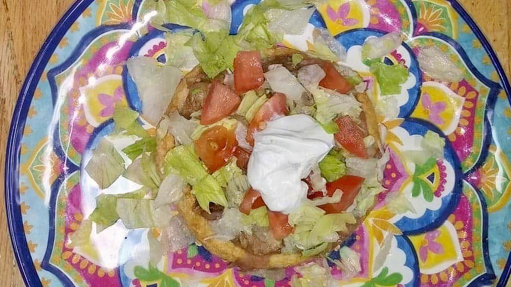 Sopes · Masa harina (ground corn flour) deep-fried and topped with beans, your choice of meat, lettuce, tomato, and sour cream.