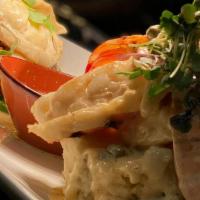 Twin Lobster · Two cold-water lobster tails topped with lemon-butter sauce, capers, and artichokes; served ...