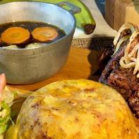 Mofongo Con Caldito De Pollo Y Carne Frita · Mashed Plantain with garlic and seasoning served with a side of chicken broth and fried chic...