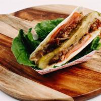 Cubano Taco · Roasted pork, sliced ham and cheese, grilled together and served with pickle and Mojo sauce