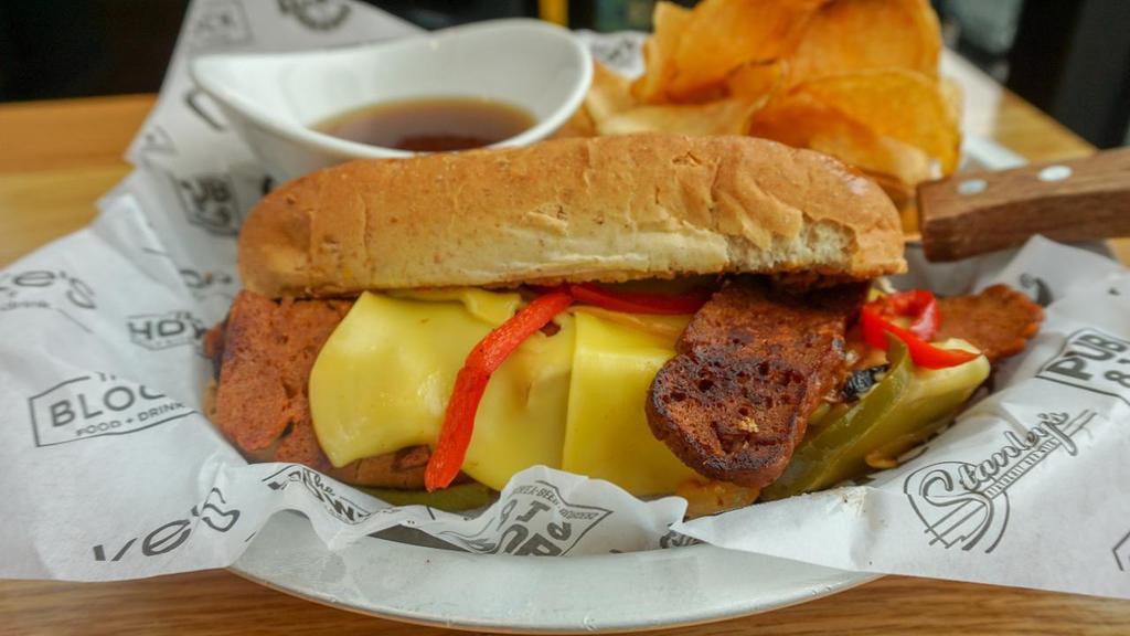 Vegan Philly · The Herbivorous Butcher's ™ vegan porterhouse, Chao vegan cheese and sauteed green and red peppers, onions, and mushrooms on a vegan hoagie roll with a side vegan au jus