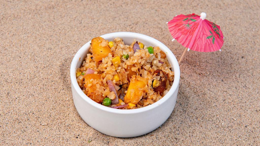 Pineapple Cauliflower Fried Rice · Roasted cauliflower rice, roasted pineapple, peas, corn, green onions, and sesame seeds with our house-made ginger garlic sauce and a protein of your choice. (Gluten-free)